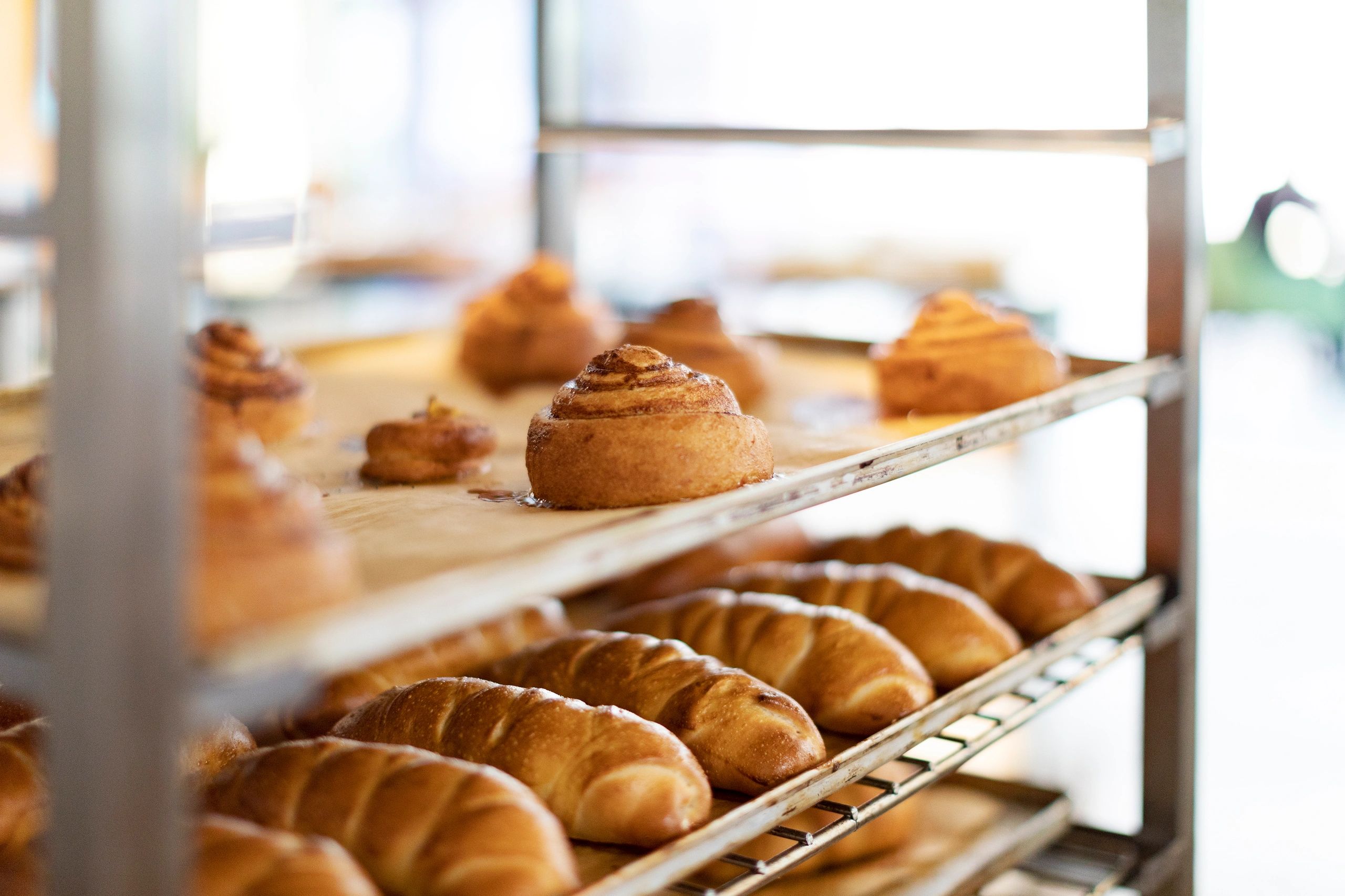 Croissants cooling on racks in a bakery production setting